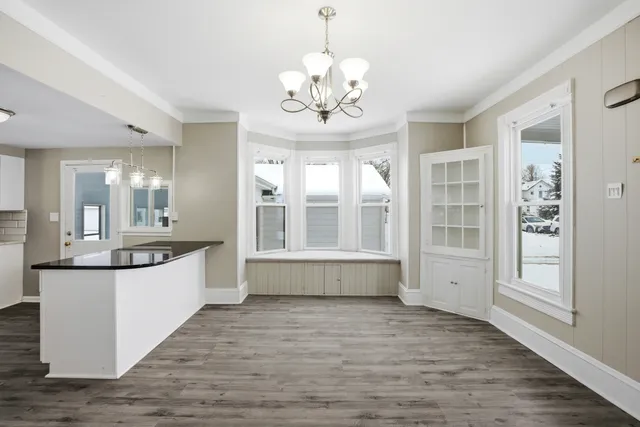 a large white kitchen with granite countertop a large counter top and sink