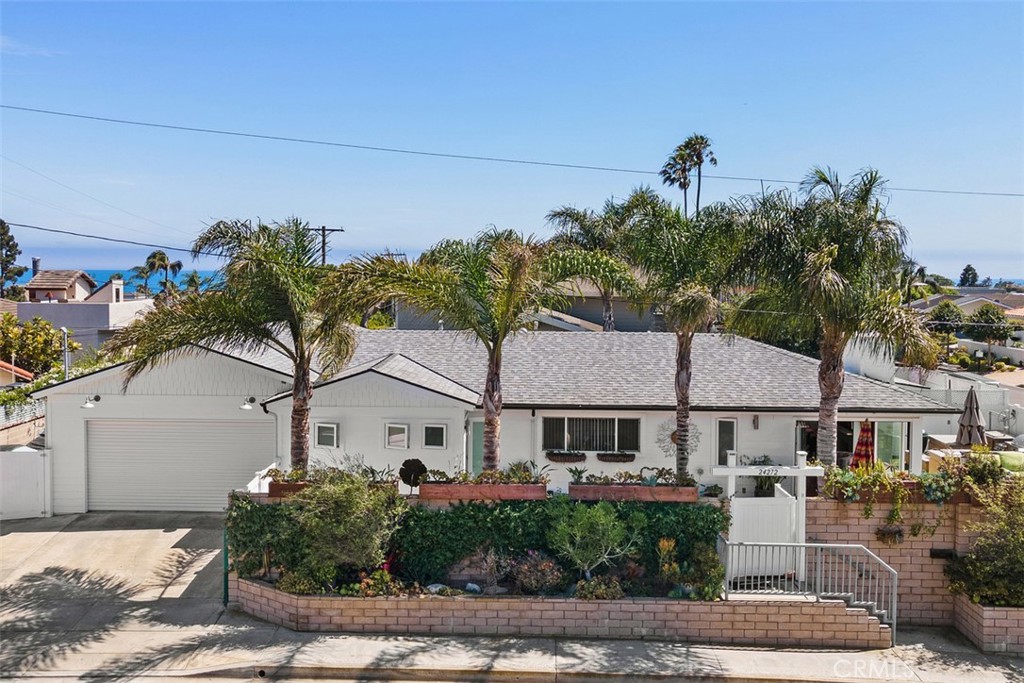 24272 Selva Road Dana Point, CA 92629 - Photo 37 of 39 a view of a white house next to a yard with potted plants