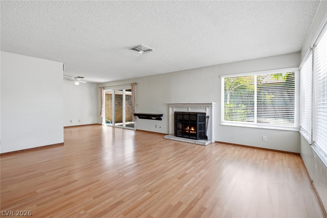 3971 Spring Leaf Drive Las Vegas, NV 89147 - Photo 4 of 48 A welcoming living room featuring a cozy fireplace and sun-filled windows.