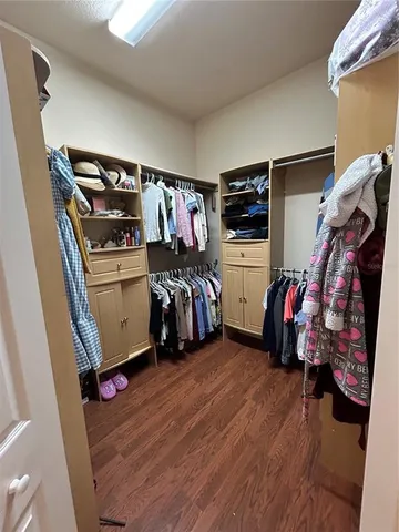 a view of walk in closet with clothes and shoes