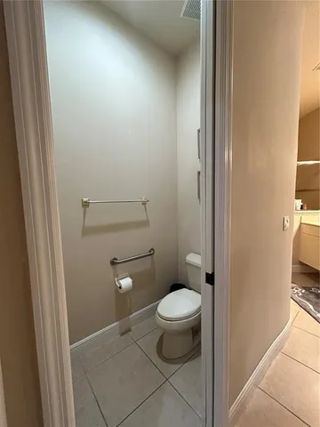 a bathroom with a granite countertop toilet and a sink