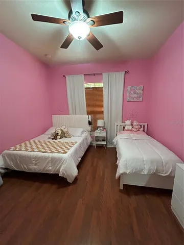 a bedroom with a bed chandelier and pink walls