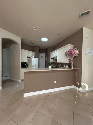 a view of kitchen with refrigerator and cabinets