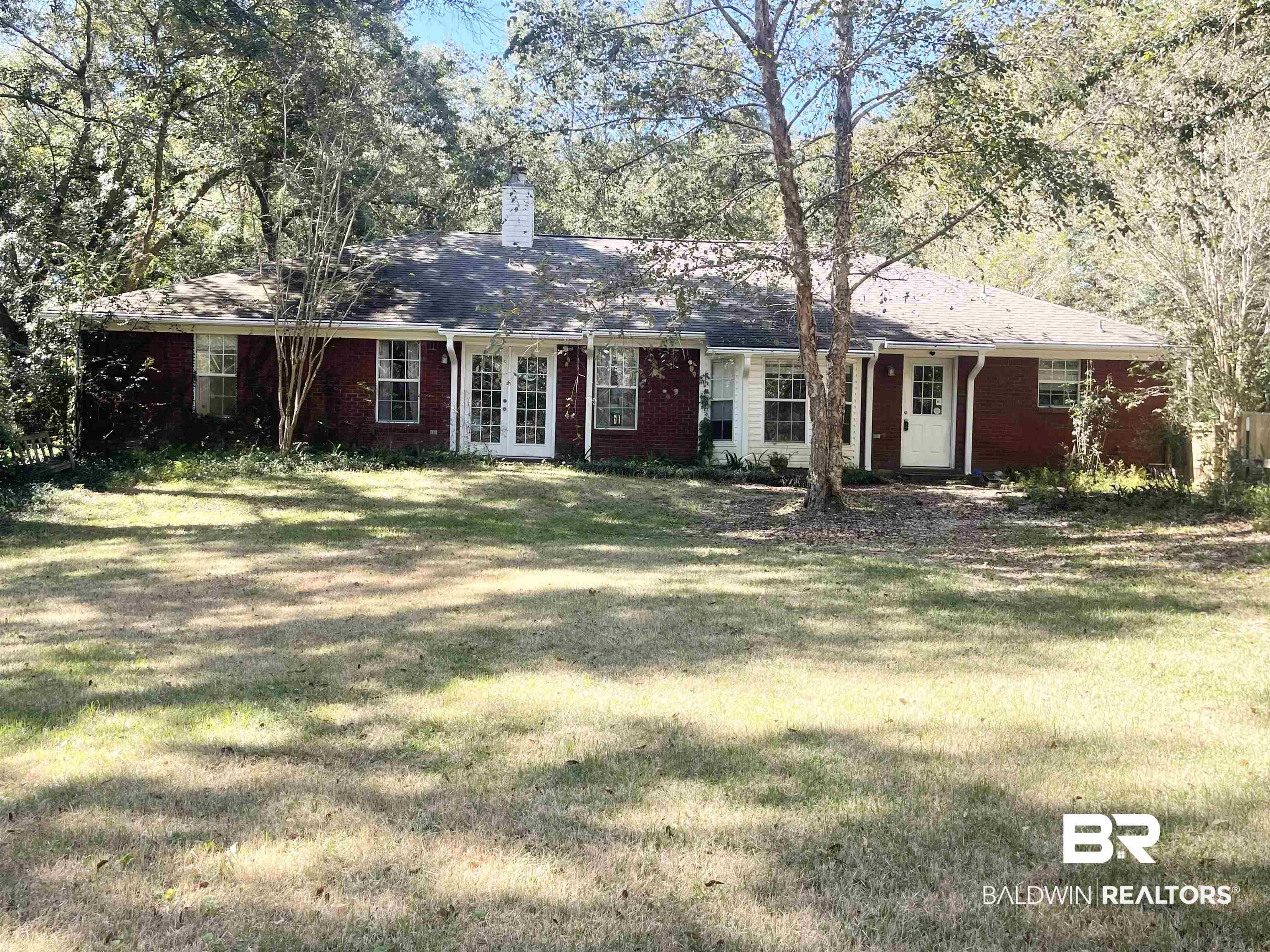 24590 Powell Road Loxley, AL 36551 - Photo 4 of 27 Ranch-style home with brick siding, french doors, a chimney, and a back lawn
