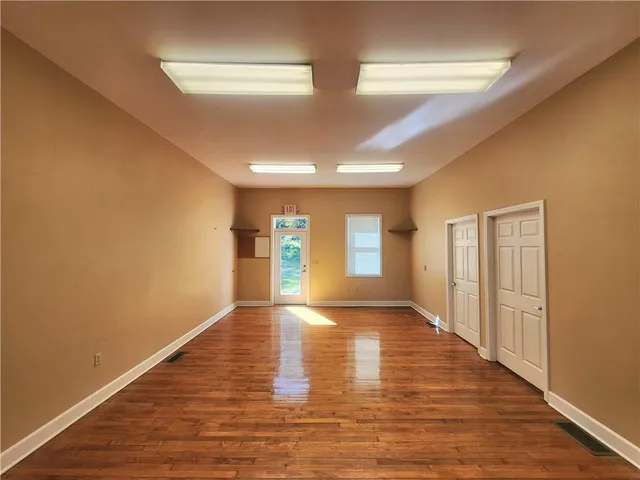 a view of empty room with wooden floor and fireplace