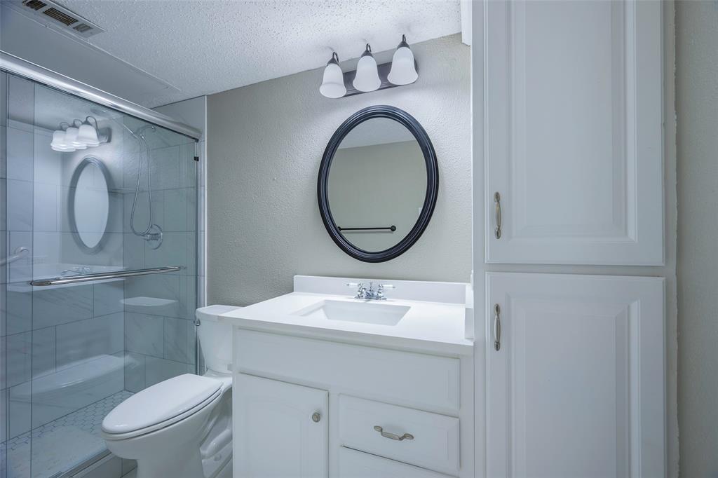 18333 Roehampton Drive, Unit 1412 Dallas, TX 75252 - Photo 11 of 14 a bathroom with a sink a toilet and a mirror