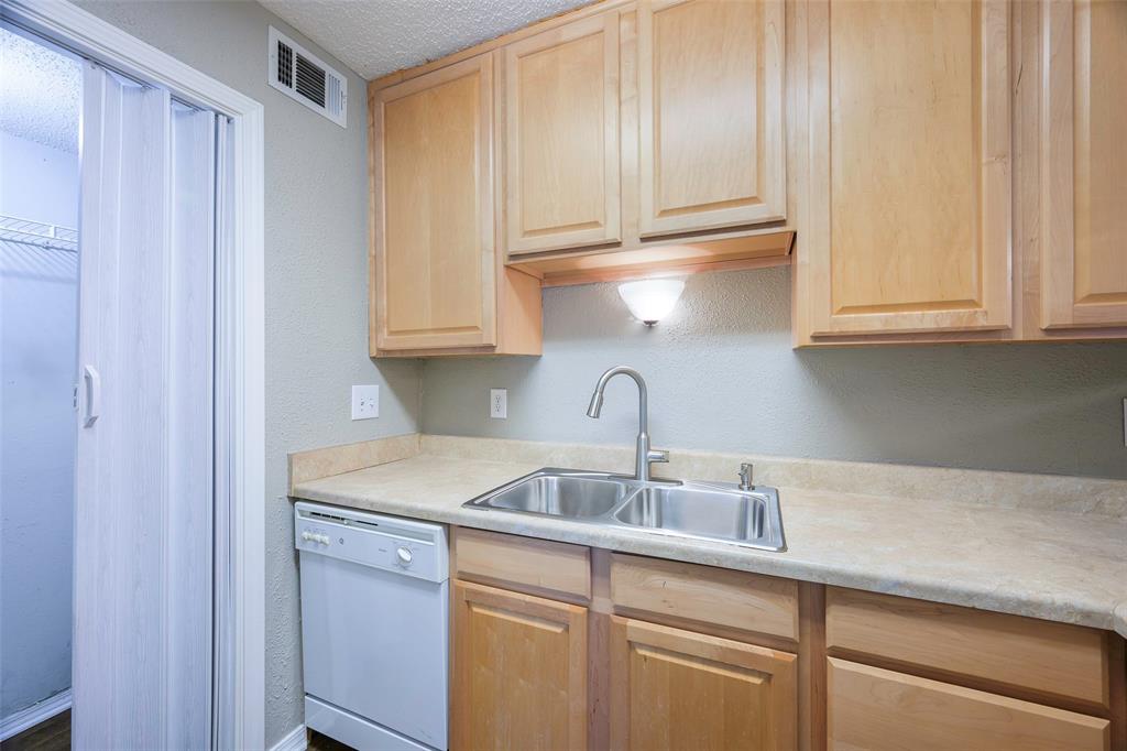 18333 Roehampton Drive, Unit 1412 Dallas, TX 75252 - Photo 8 of 14 a kitchen with stainless steel appliances granite countertop a sink and a white cabinets
