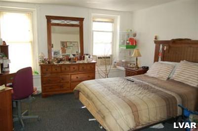 128 South 12th Street Allentown, PA 18102 - Photo 17 of 19 a bedroom with a bed and wooden floor