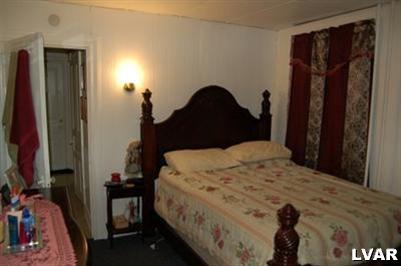 128 South 12th Street Allentown, PA 18102 - Photo 5 of 19 a bed sitting in a bedroom next to a window