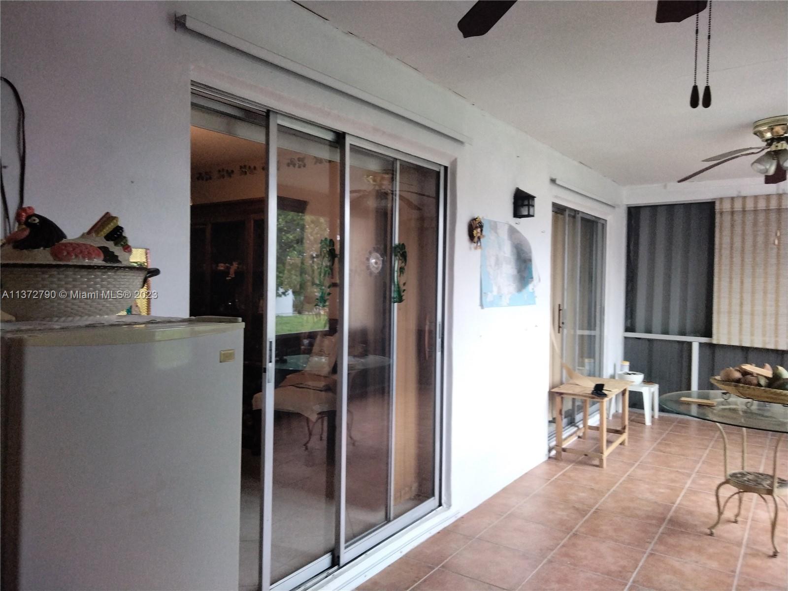 Paradise Gardens Margate, FL 33063 - Photo 5 of 12 a room with chandelier fan and glass door