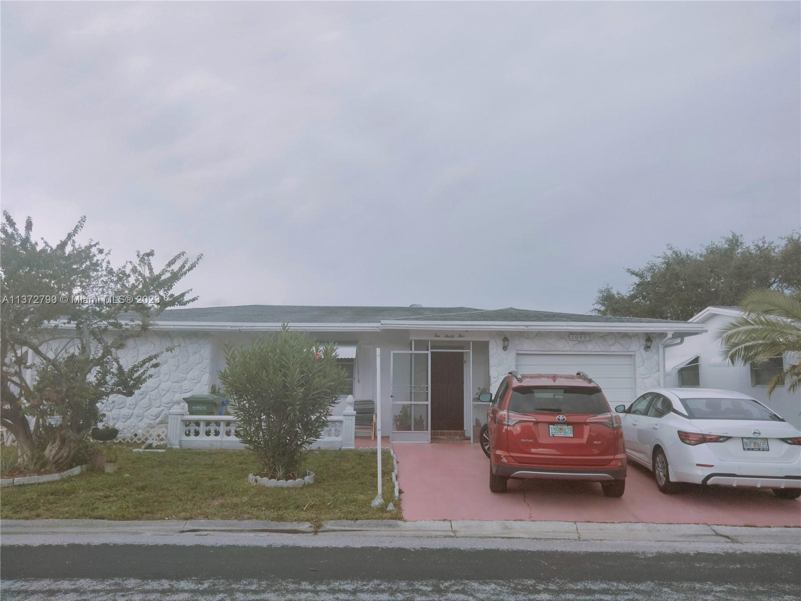 Paradise Gardens Margate, FL 33063 - Photo 6 of 12 a car parked in front of white house