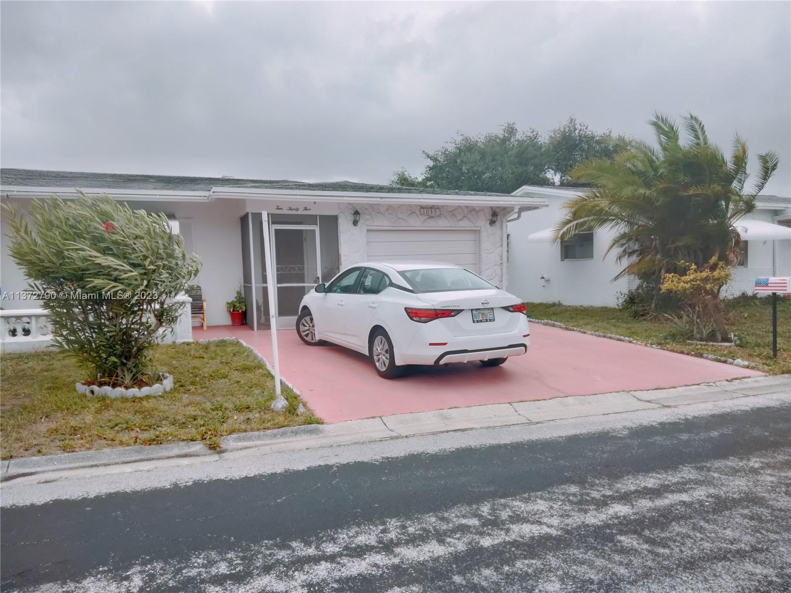 Paradise Gardens Margate, FL 33063 - Photo 7 of 12 a car parked in front of white house