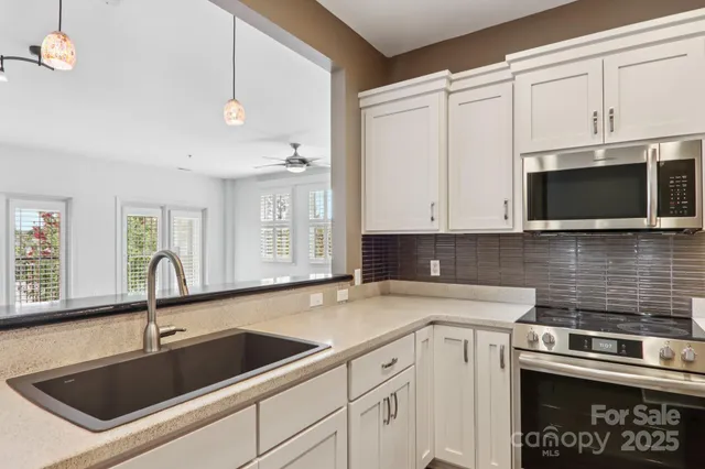a kitchen with stainless steel appliances granite countertop a sink and a microwave