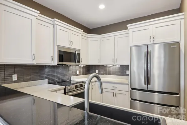 a kitchen with stainless steel appliances a refrigerator sink and cabinets