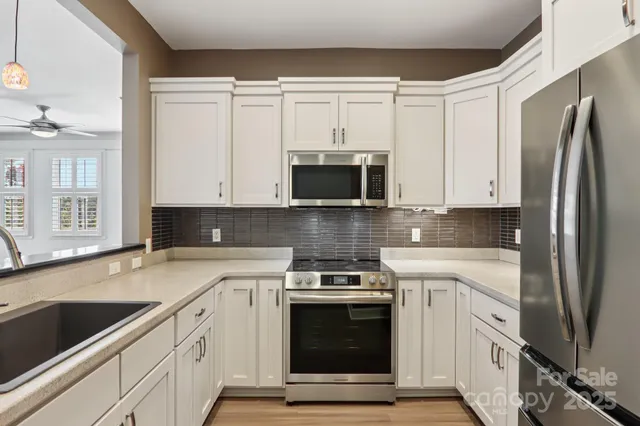a kitchen with stainless steel appliances granite countertop a stove a microwave and a refrigerator
