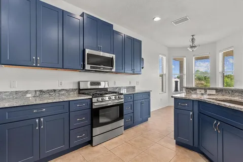 a kitchen with granite countertop wooden cabinets and stainless steel appliances