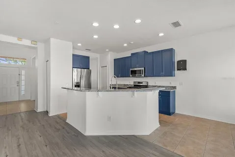 a kitchen with stainless steel appliances granite countertop a stove top oven a sink and a refrigerator