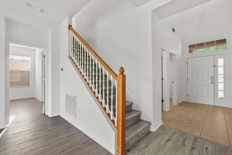 a view of a hallway with wooden floor and entryway