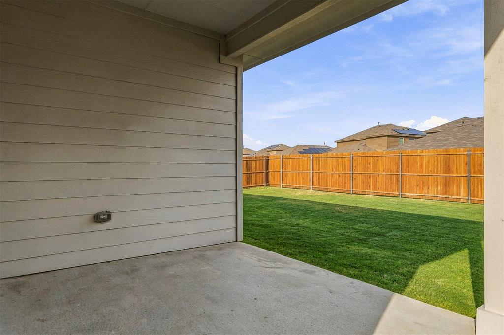 15932 Stableford Road Justin, TX 76247 - Photo 25 of 35 Covered concrete patio with siding exterior, opening to a fenced backyard featuring a manicured lawn