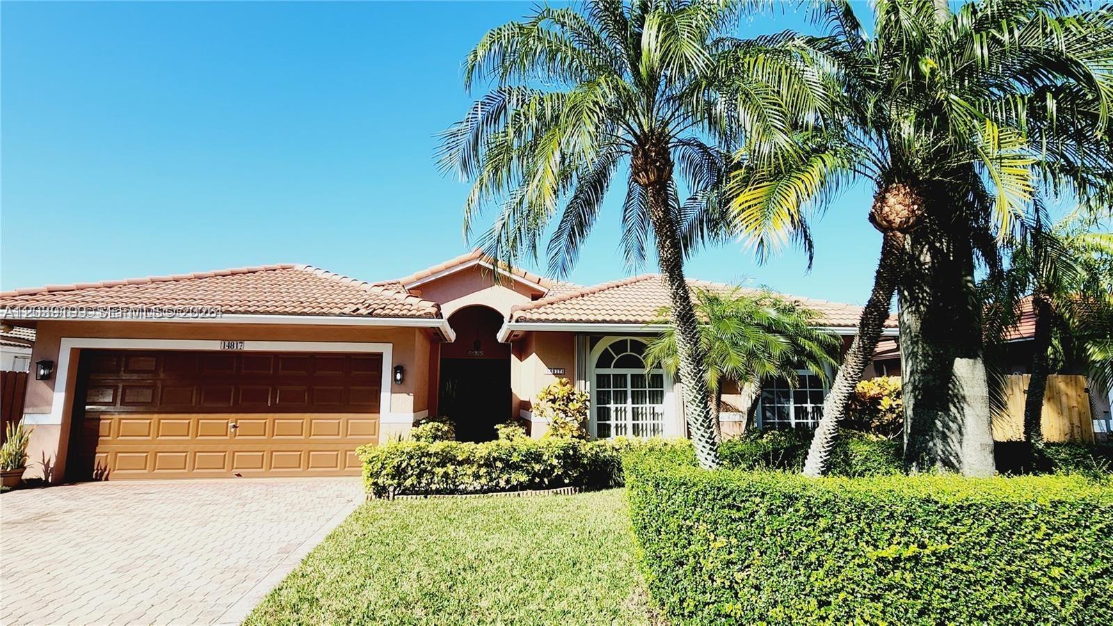 14817 Southwest 180th Street Miami, FL 33187 - Photo 1 of 15 a front view of a house with a yard
