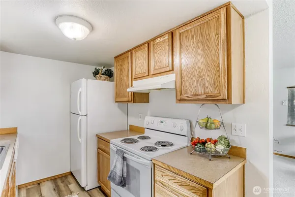 a kitchen with a refrigerator and a stove top oven
