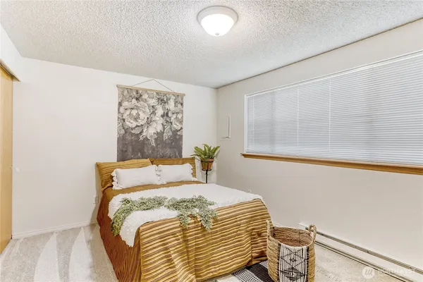 a bedroom with a bed and a window with the outer view