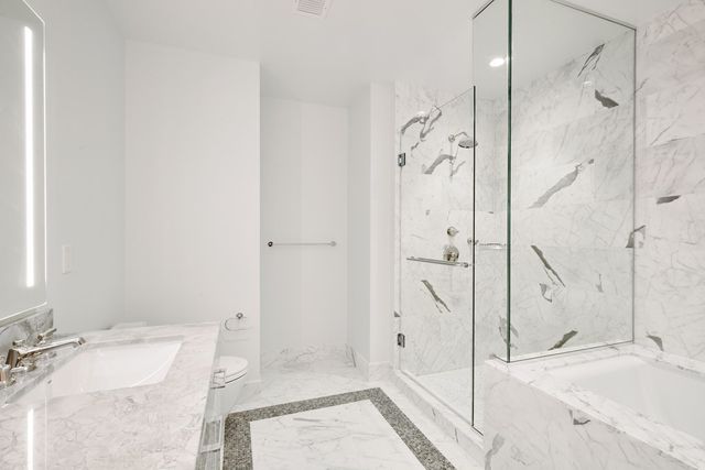 a bathroom with a sink a toilet and shower