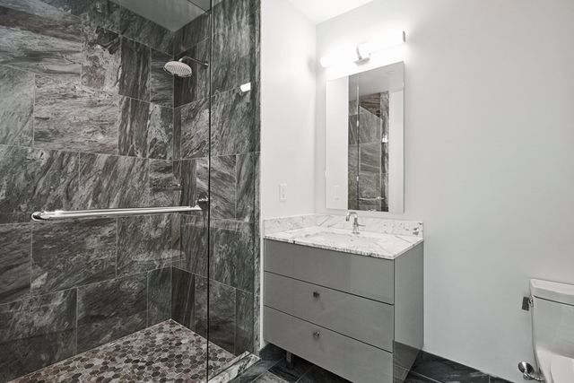 a bathroom with a granite countertop sink a mirror and a bathtub