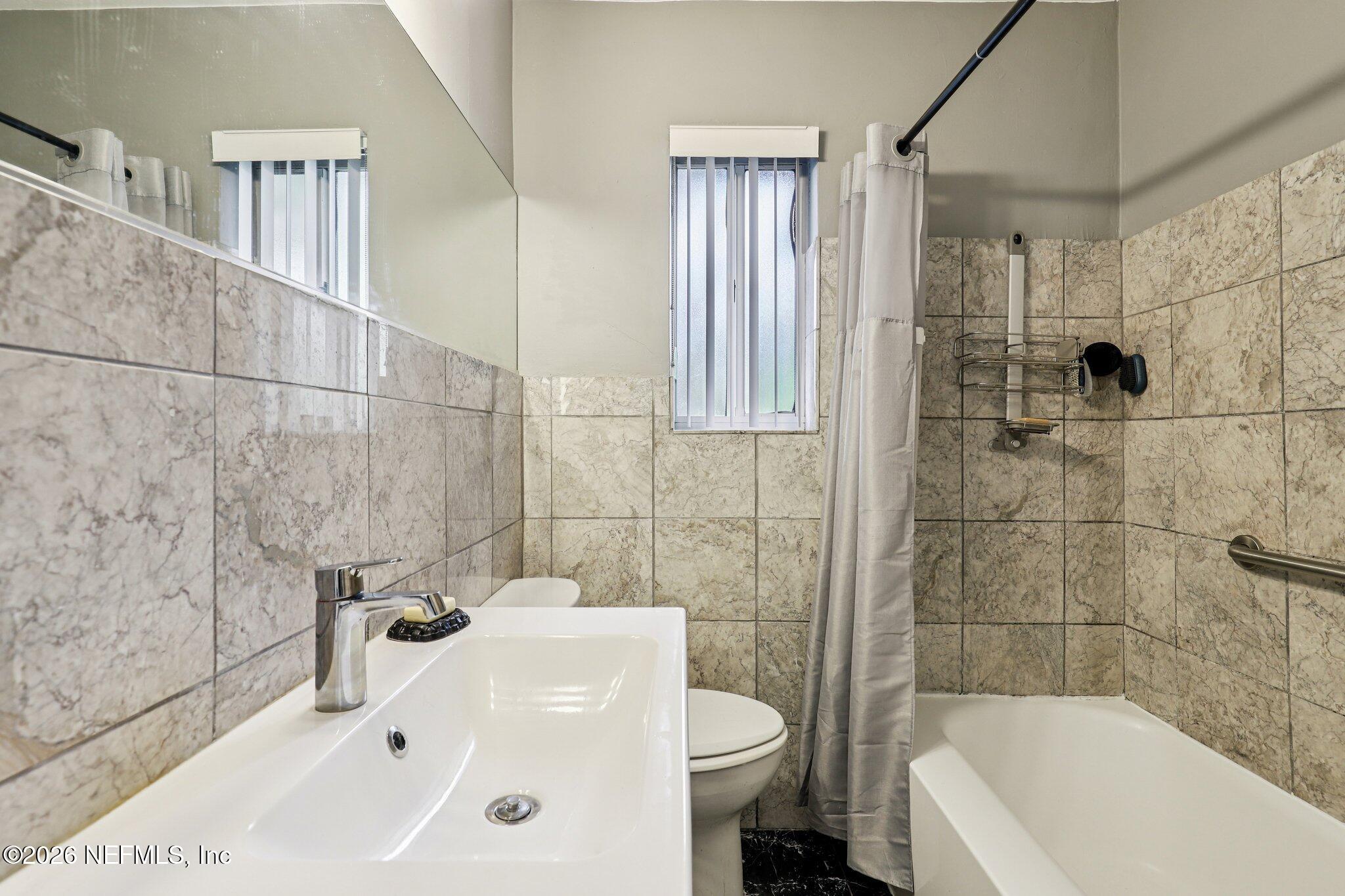 2159 Riverside Avenue, Unit 4 Jacksonville, FL 32204 - Photo 24 of 50 a bathroom with a sink and mirror with bathtub
