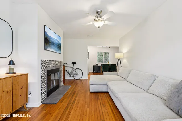 a living room with furniture a fireplace and wooden floor