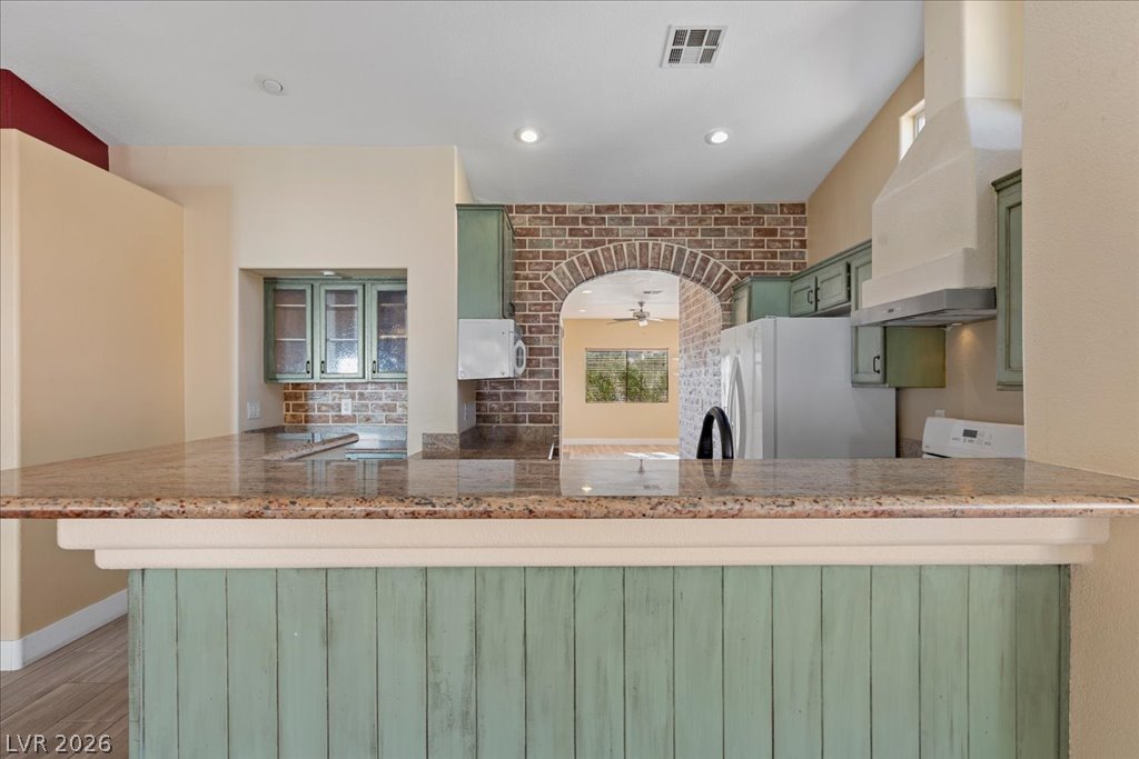 120 Ringlore Road Henderson, NV 89015 - Photo 13 of 58 Polished granite countertops wrap around this kitchen featuring an arched brick wall detail.