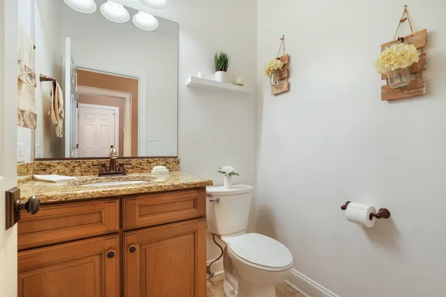 a bathroom with a granite countertop sink mirror and toilet