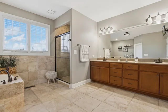 a spacious bathroom with a granite countertop sink mirror and bathtub
