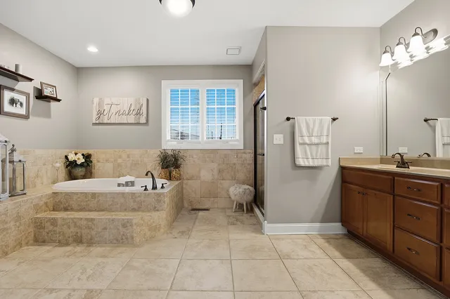 a spacious bathroom with a tub sink and mirror