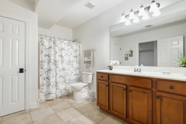 a bathroom with a double vanity sink mirror and toilet