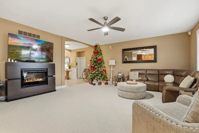a living room with furniture a flat screen tv and a fireplace