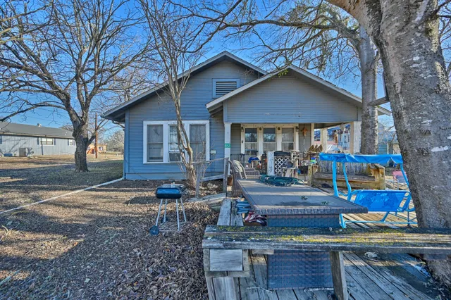a front view of a house with garden and trees