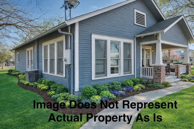 a view of a brick house with a flower garden
