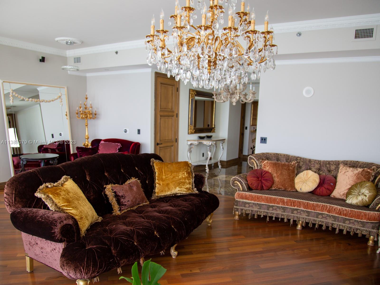 a living room with furniture and a chandelier