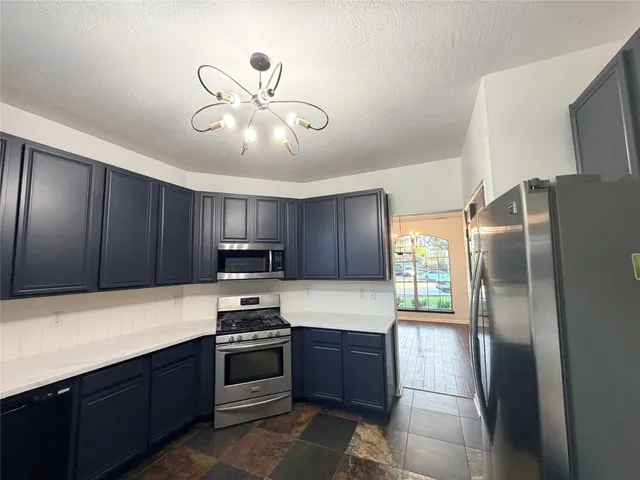 a kitchen with granite countertop stainless steel appliances and a refrigerator