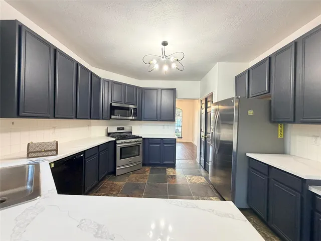 a kitchen with granite countertop stainless steel appliances and wooden cabinets