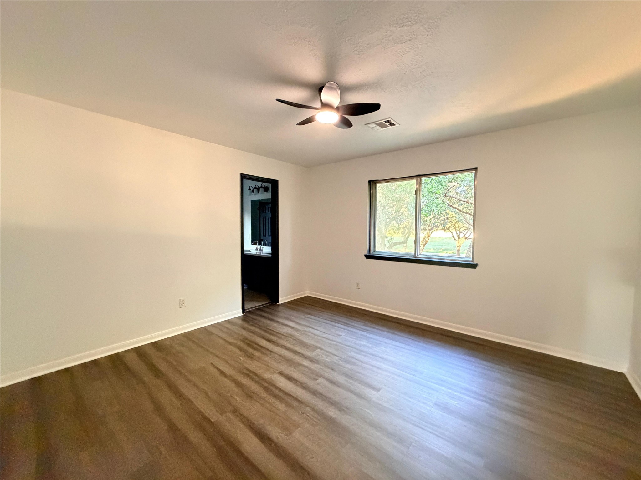 13002 Bainbridge Trail Houston, TX 77065 - Photo 23 of 32 an empty room with wooden floor ceiling fan and windows