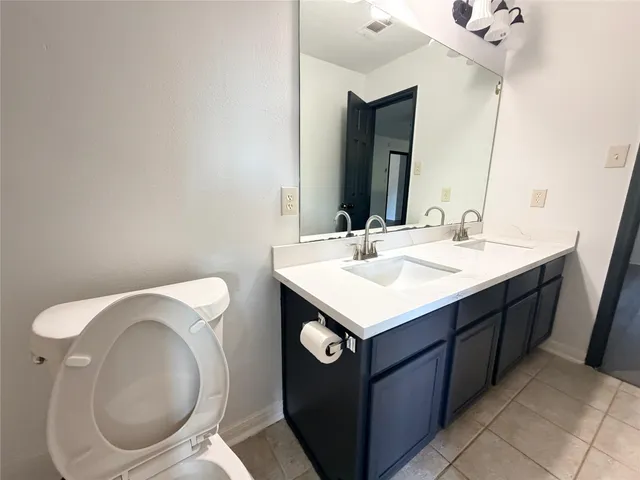 a bathroom with a sink vanity mirror and toilet