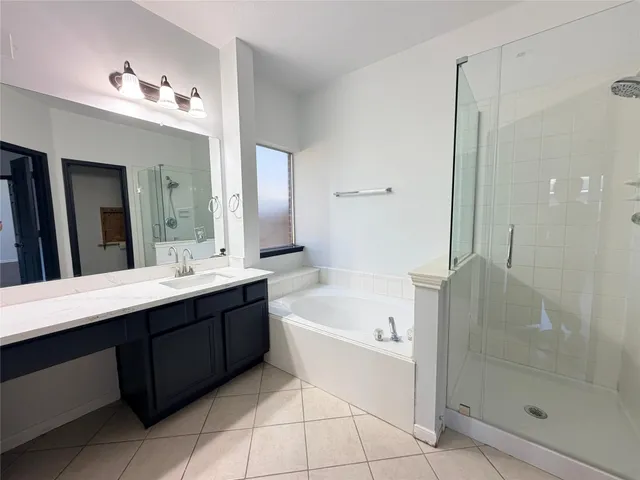 a bathroom with a tub sink shower and mirror