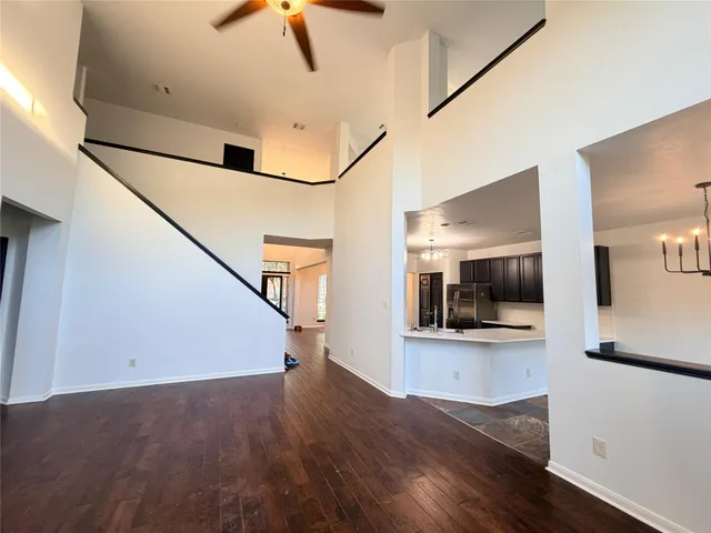 a view of a hallway with wooden floor and staircase