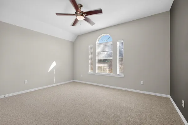 en empty room with windows and ceiling fan