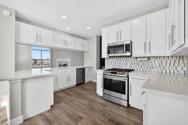 a kitchen with white cabinets stainless steel appliances and sink