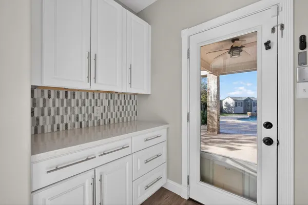a kitchen with granite countertop white cabinets and white appliances