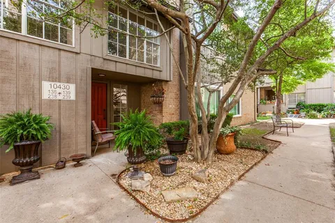a view of a building with sitting area and potted plants