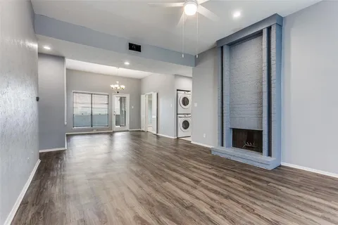 an empty room with wooden floor and a fireplace